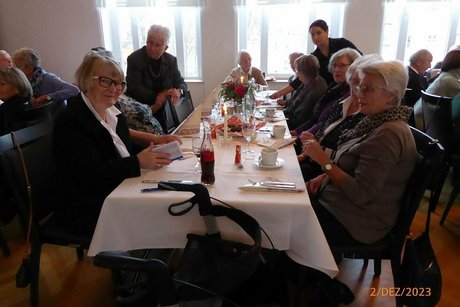Eine Gruppe Menschen sitzt gemeinsam an einem Tisch.