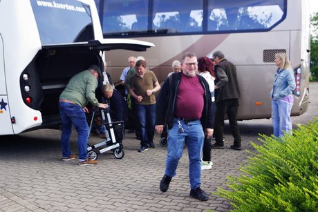 Hilfsmittel Ein Rollator wird durch Helfer im Bus verstaut