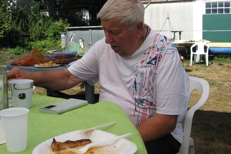 Grillnachmittag. Ein Mann sitz an einem Gartentisch.