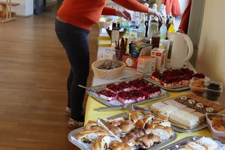 Treffen der Vertreterinnen der Frauen im Mehrgenerationenhaus. Langer Tisch mit Kuchen, Schnittchen und Getränken für die Veranstaltung.