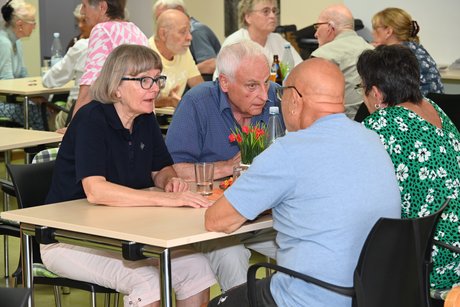 Menschen sitzen am Tisch bei einer Unterhaltung