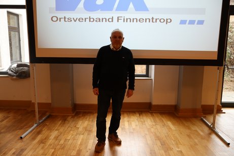 Vorsitzender A. Hasenau vor der Leinwand vor der JHV