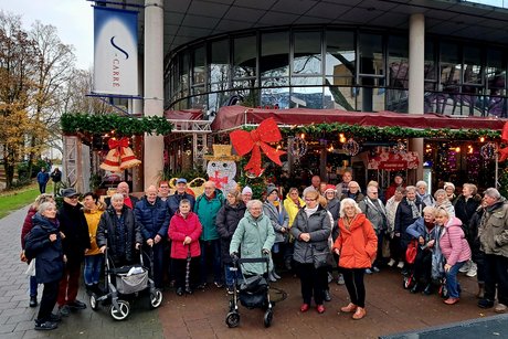 Gruppenbild mit Teilnehmern vor weihnachtlicher Kulisse