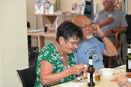 Menschen sitzen am Tisch beim Essen