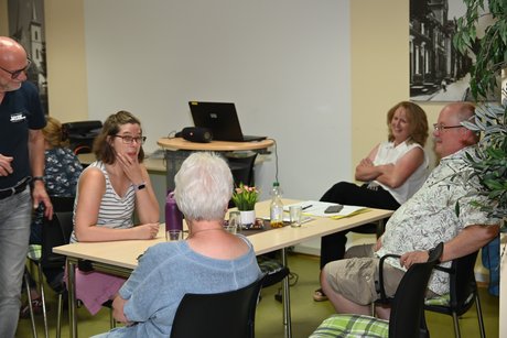 Mitglieder sitzen an einem Tisch und unterhalten sich