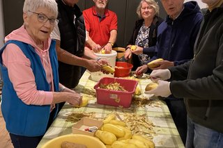 Mitglieder des OV Mettingen schälen Kartoffeln für die Reibekuchen