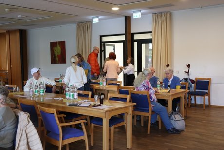 Jahreshauptversammlung 2026 Im Eingang stehen eintreffende Mitglieder und andere sitzen bereits an langen Tischen.
