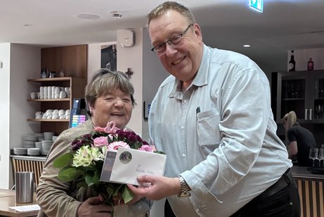 Auf dem Foto ist Reinhilde Zittlau zu sehen wie sie vom Kreisvorsitzenden Dirk Schilder mit einem Strau&szlig; Blumen verabschiedet wird