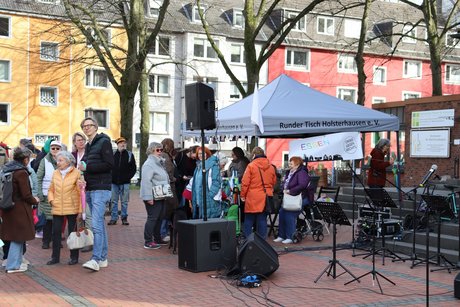Viele Menschen stehen um einen Stand herum.
