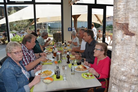 Menschen sitzen am Tisch und essen zu Mittag