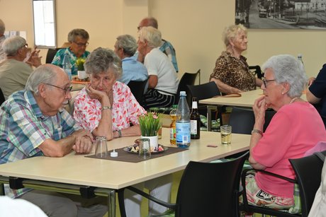 Menschen sitzen am Tisch bei einer Unterhaltung