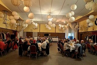 Viele Menschen sitzen gemeinsam beim Essen