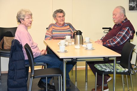 Mitglieder sitzen an einem Tisch und unterhalten sich