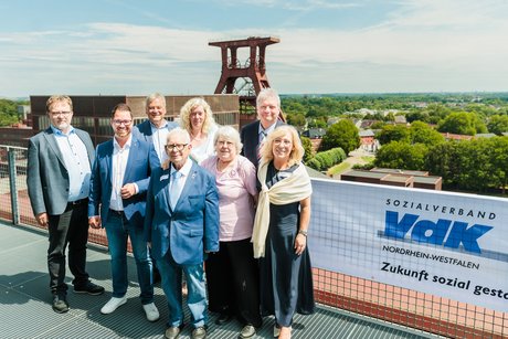 8 Personen stehen zusammen für in Foto.