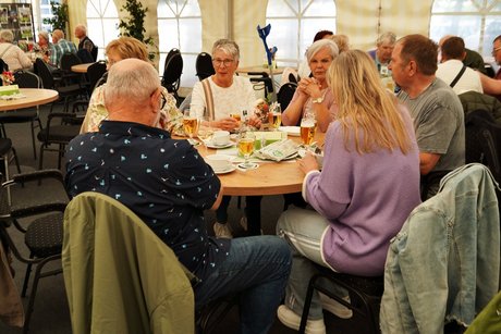 Spagelessen Menschen sitzen am Tisch. Auf dem Tisch stehen Getränke