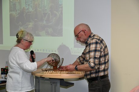 Zwei Menschen ziehen die Bingo-Kugeln