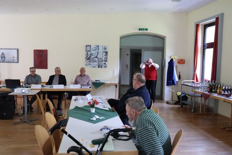 Jahreshauptversammlung 2026 Mehrere Personen sitzen an langen Tischen und unterhalten sich miteinander.