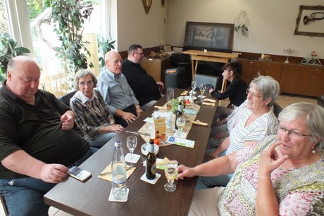 Menschen sitzen an einem langen Tischen.