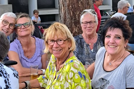 Fröhliche Ecke Lachende Gruppe am Tisch