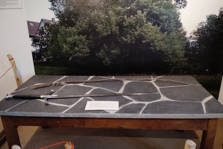 Ein Tisch mit Schwert zum Schwur und Strick vor dem Hintergrundbild eines Baums