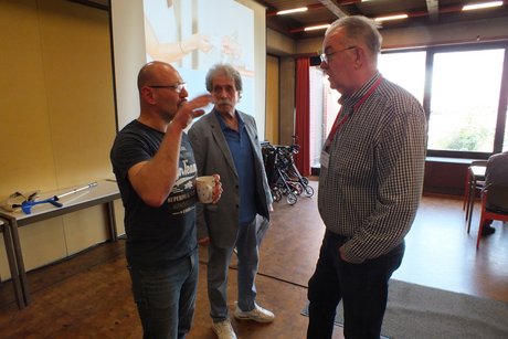 Drei M&auml;nner unterhalten sich.