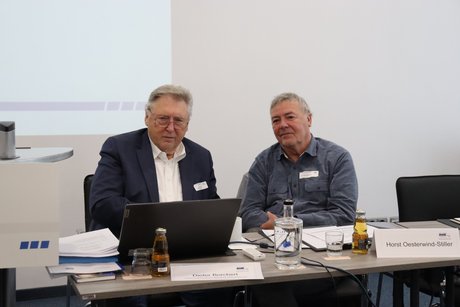Zwei M&auml;nner sitzen vor einem Notebook und bereiten sich f&uuml;r die Veranstaltung vor.