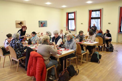 Treffen der Frauenvertreterinnen im Mehrgenerationenhaus. Vertreterinnen der Frauen sitzen an einem langen Tisch zusammen.