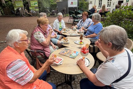Das Foto zeigt Menschen im Eiscaf&eacute;
