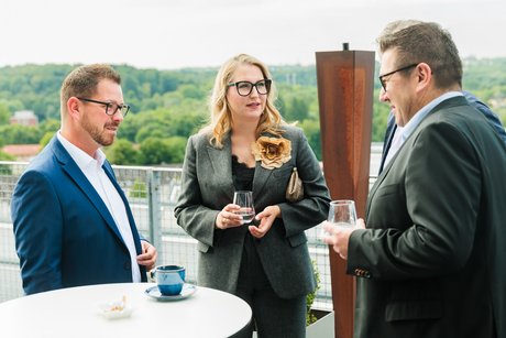 Vier Personen unterhalten sich auf der Außenplattform der Zeche Zollverein miteinander.