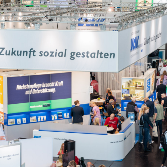 Der VdK-Messestand auf der D&uuml;sseldorfer Rehacare mit gro&szlig;em Banner mit Logo und Slogan: Zukunft sozial gestalten.
