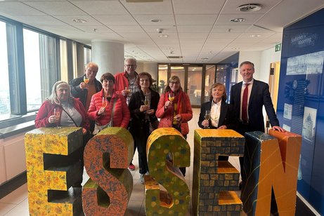 8 Personen stehen hinter dem Wort Essen, in großen Buchstaben.