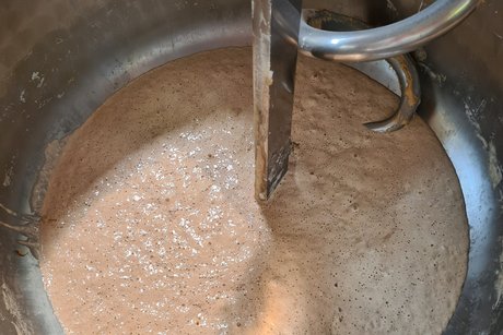 Besuch bei Bäckerei Peter. Ein großes Gefäß mit Teig in einer Knetmaschine.