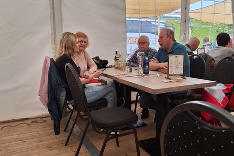Mitglieder aus 2 Ortsverbänden sitzen im Zelt auf dem Spargelhof Juppis.