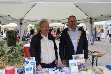 2 Männer stehen hinter einem VdK Informationsstand.
