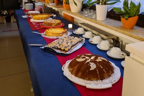 Auf einem langen Tisch stehen mehrere Torten.