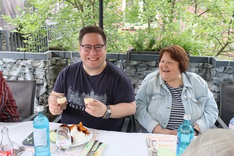 Grillnachmittag vom VdK Ortsverband Altendorf gemeinsam mit dem Ortsverband Borbeck. Ein Mann und eine Frau sitzen am Tisch vor ihrem Essen.