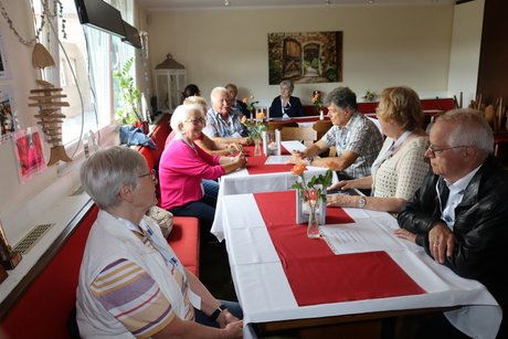 Mitglieder vom Ortsverband sitzen an Tischen.