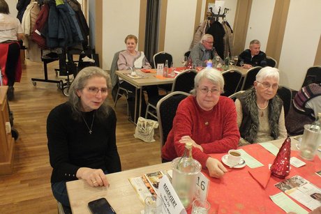 Drei Frauen sitzen an einem Tisch.