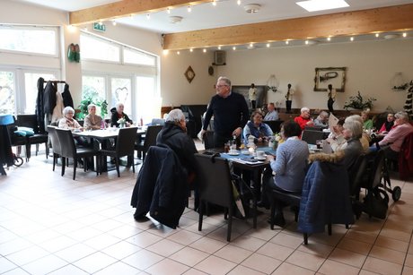 Frühlingsfest Mehrere Menschen sitzen an vier großen Tischen und unterhalten sich.