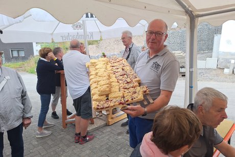 Ein Mitglied der Backgemeinschaft bringt neuen Kuchen zum Buffet.