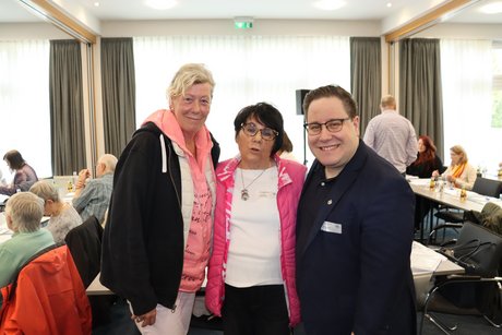 Zwei M&auml;nner und ein Mann stehen f&uuml;r ein Foto zusammen.
