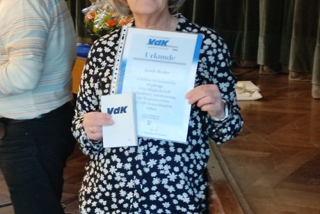 Mitglied h&auml;lt ihre Urkunde hoch