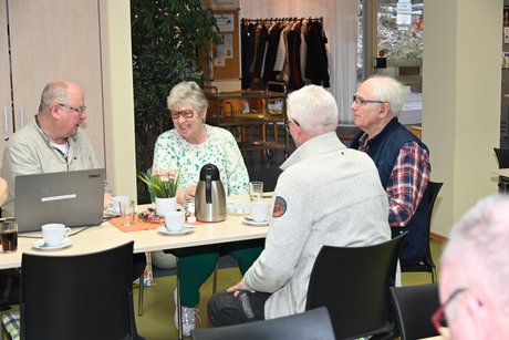 Mitglieder sitzen an einem Tisch und unterhalten sich
