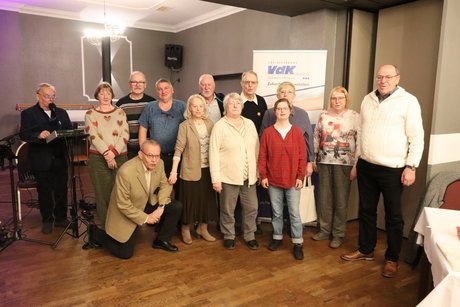 Mehrere Personen stehen zum Gruppenbild zusammen.