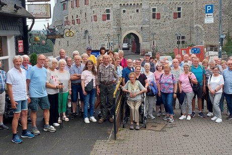 Viele Personen stehen vor einer Burg