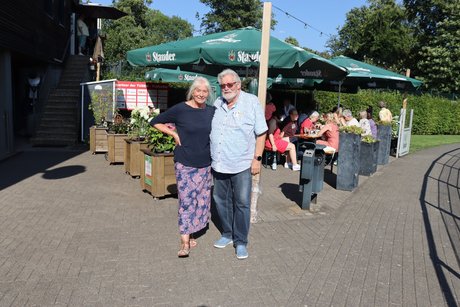Mann und Frau stehen für ein Foto vor dem Biergarten.