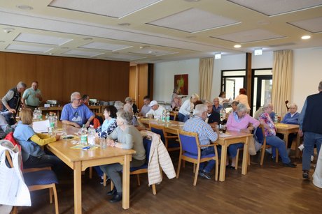 Jahreshauptversammlung 2026 Mehrere Menschen sitzen an drei langen Tischen und reden miteinander.