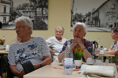 Mitglieder sitzen an Tischen
