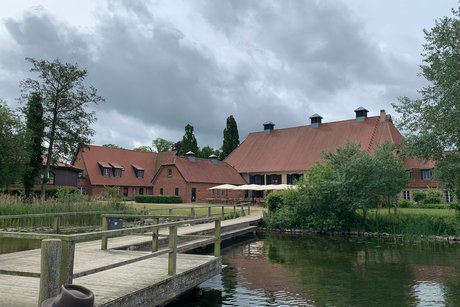 Immenhof Steg am See mit Hofgebäuden im Hintergrund
