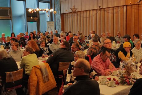 Viele Menschen sitzen an den Tischen